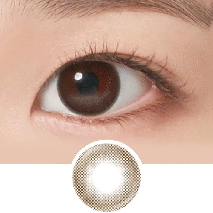 A close-up of a brown eye with natural makeup, long lashes, and a defined brow. Below is the NEO Vision Neoism Coco Brown (50pk) by NEO Vision—stylish prescription colored contacts featuring a coco brown shade and transparent center.