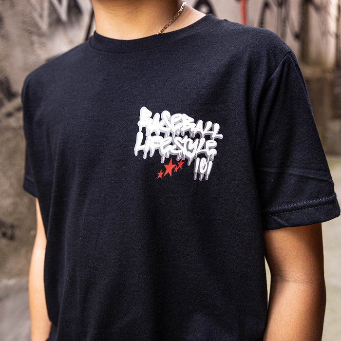 Youth model wearing black youth graphic tee with "Night Game Drip" design