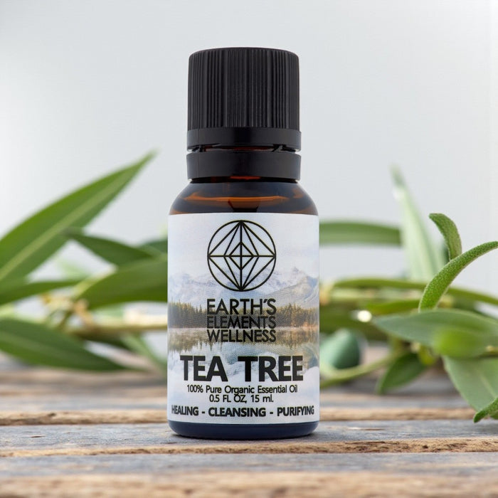 Bottle of Earth's Elements Wellness Tea Tree essential oil with green leaves in the background