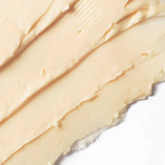 Close-up of a smooth, beige-colored cream or lotion on a white background