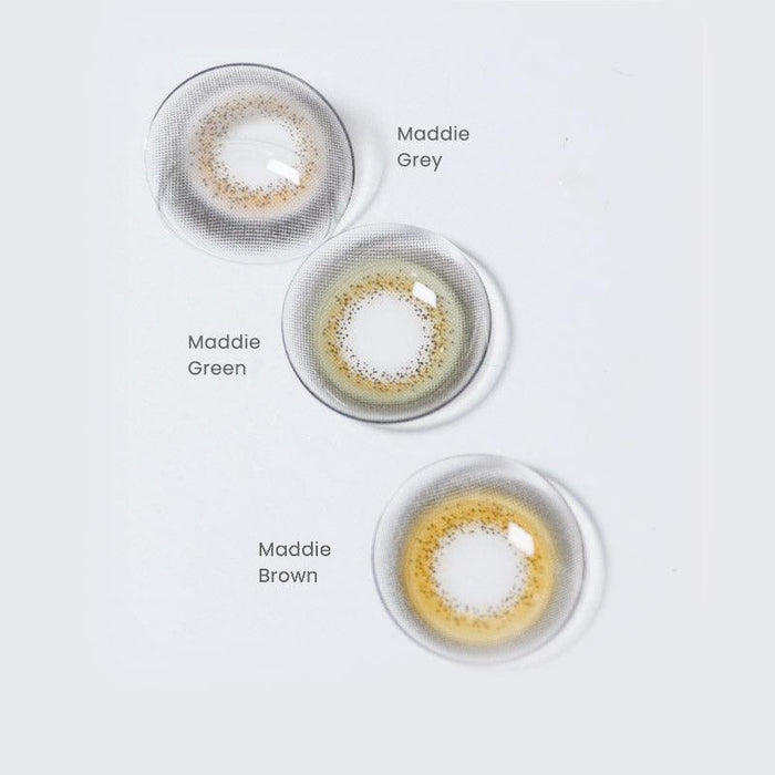 Assortment of Maddie prescription colored contact lenses in various shades: grey, green and brown on a white background.