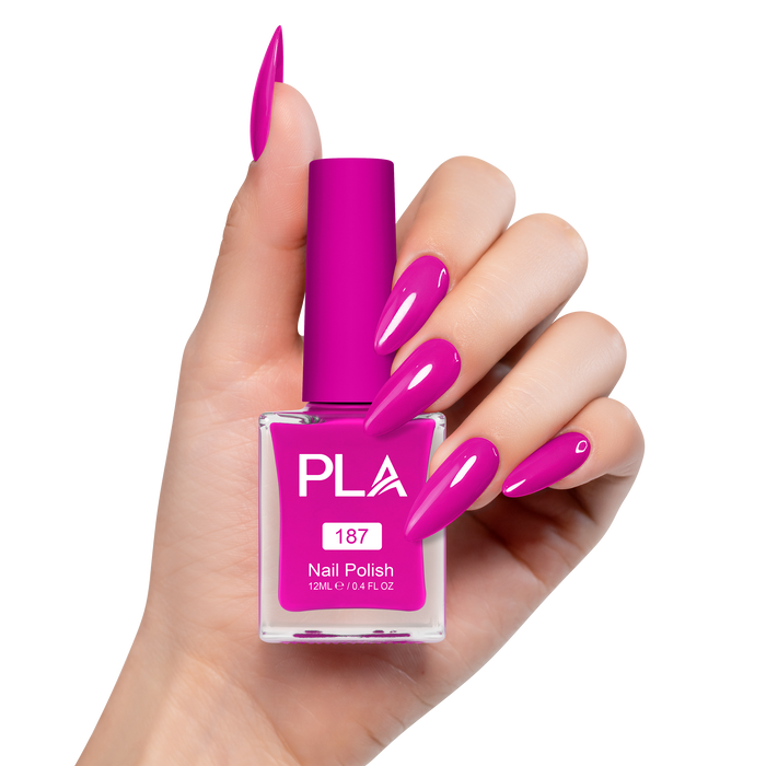 Hand holding a pink nail polish bottle with matching nails on a white background