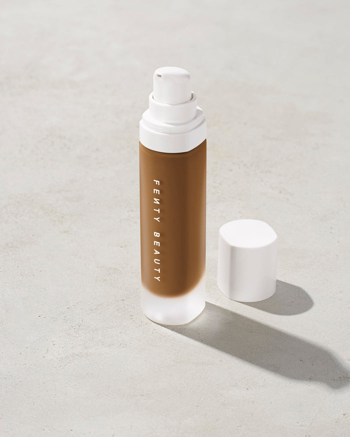 open bottle of Fenty Beauty Pro Filt'r Soft Matte Longwear Foundation with pump dispenser in shade 445 on concrete background