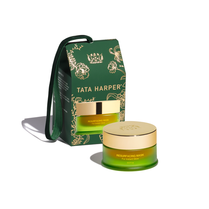 Tata Harper Resurfacing Mask facial cream jar in front of its green and gold illustrated packaging box, set against a clean white background.