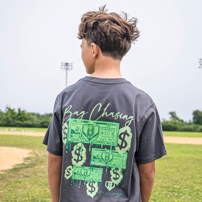 Person wearing black t-shirt with 'Bag Chasing' text and green dollar bill dripping graphic