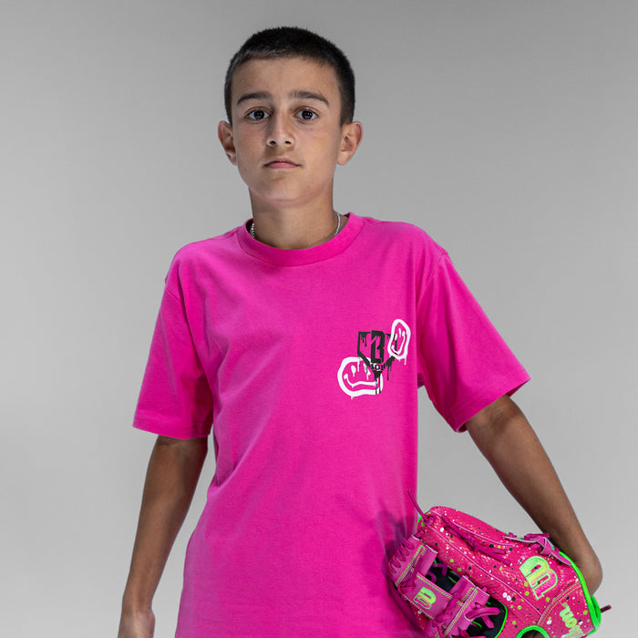 Child wearing pink t-shirt with a black BL101 logo and white smiley face graphics with a pink baseball glove