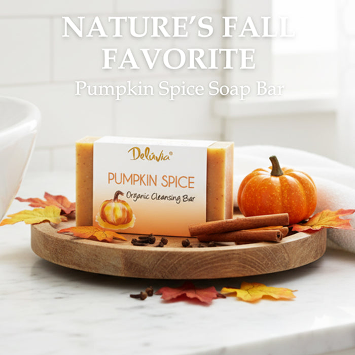 A bar of Deluvia Pumpkin Spice Soap on a wooden try with cinnamon sticks and autumn leaves.