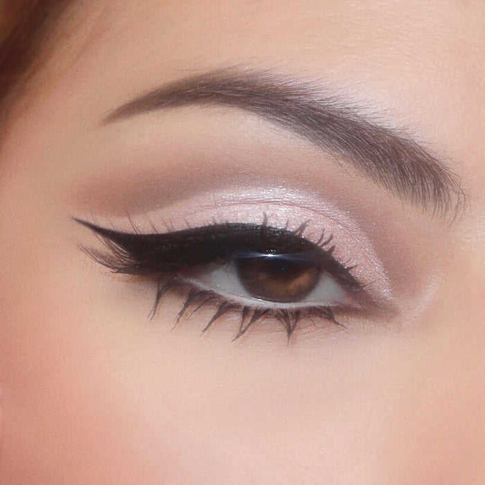 Close-up eye wears cool taupe shimmer and soft mauve crease from the Stone Cold Fox shadow palette, finished with a sharp black wing and defined lashes, showcasing a neutral glam look from the ColourPop Shadow Palette collection.