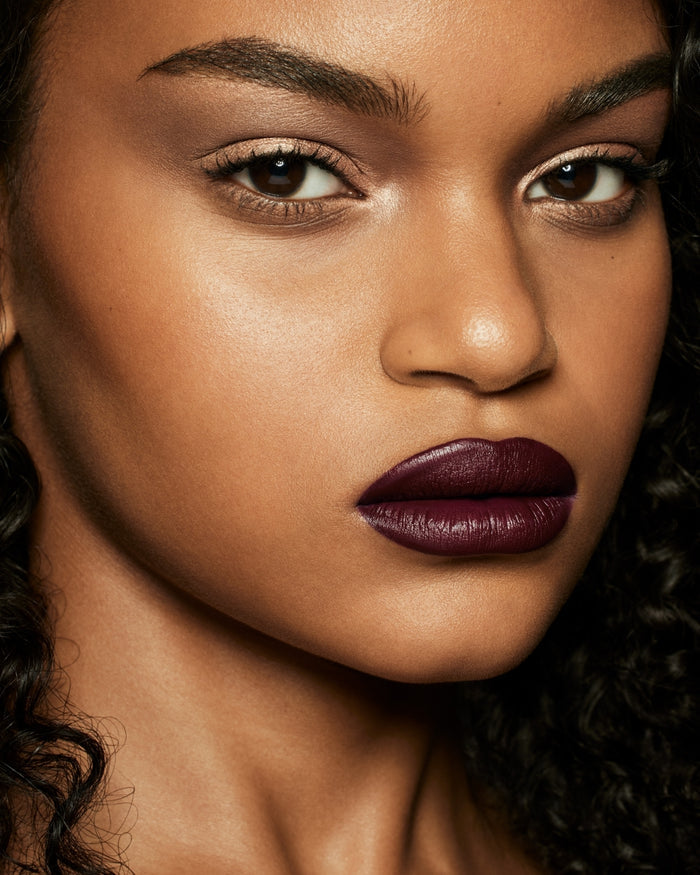 medium skin toned model wearing stunna lip paint in the shade underdawg