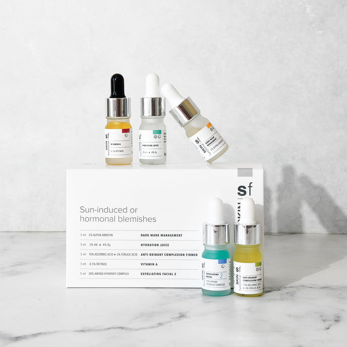 SKIN Functional Sun Induced Skin Treatment Kit with details skincare product on a grey background