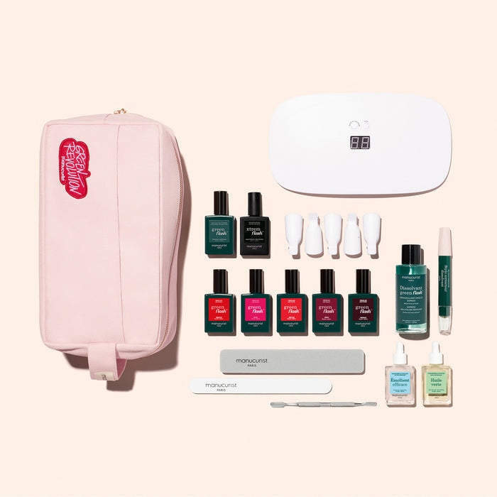 The Manucurist Super Ultimate Kit includes a pink zippered pouch, white UV lamp, 7 Green Flash gel polishes, nail files, cuticle tools, remover bottles, and accessories for an ultra-glossy manicure—all stylishly displayed.
