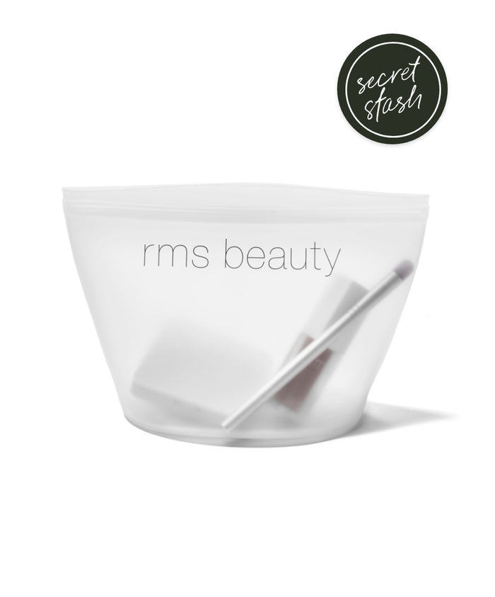 Clear silicone pouch labeled rms beauty containing clean beauty tools, shown with a Secret Stash badge, representing a Sustainable Makeup Bag ideal for eco-friendly makeup storage.