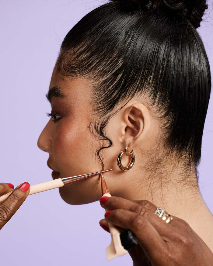 model with topknot and gold hoops with swooped baby hairs