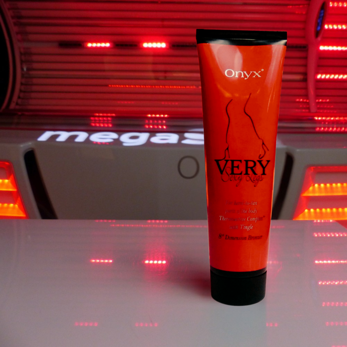 Tubka Onyx Very Sexy Legs na tle czerwonego światła w solarium. Bronzer do nóg z efektem tingle, który pobudza skórę i wspomaga szybkie opalanie.