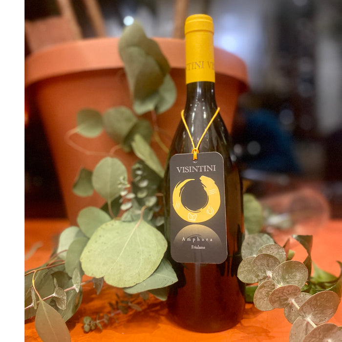 Visintini Friulano wine bottle with yellow cap and black label, with eucalyptus leaves